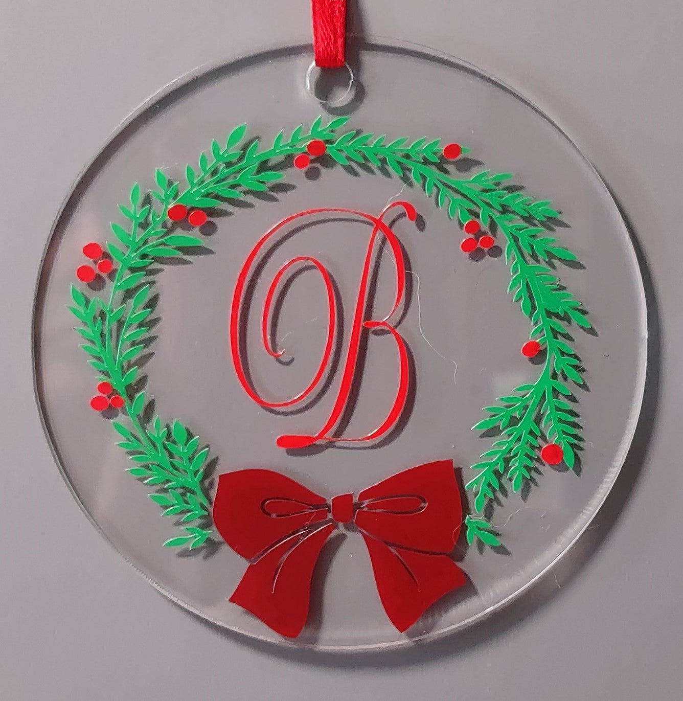 Decorative ornament with green wreath, red 'B', and bow