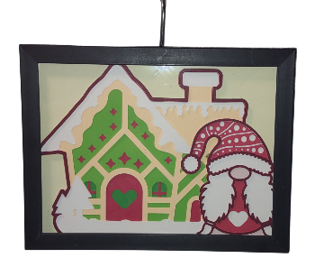 Decorative Christmas ornament with a gingerbread house and Santa Claus figure